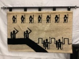 Large crocheted tapestry with hanging bar, depicts medieval soldiers in battle