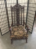 Antique carved mahogany parlor arm chair with intricate back and original upholstery