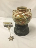 Famille rose Cloisonne porcelain vase with twin handles and gilt accents on a wood base