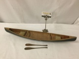 Vintage model canoe with a pair of wood carved paddles