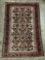 Vintage wool rug with intricate floral design in brown and red tones with orange/pink highlights