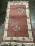 Thick wool rug with fringe, natural tones with geometric and floral designs