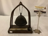 Antique metal bell hung from wood carved stand with beater