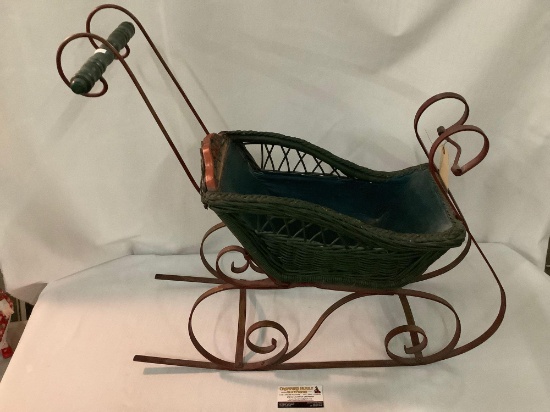 Antique doll sleigh w/ metal frame, wicker basket and wood accents, approx 30x27x11 inches.