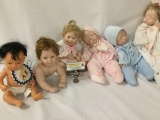 Six vinyl and porcelain baby dolls from makers like Boots Tyner and Furga, largest doll measures