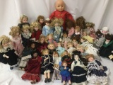 Over thirty porcelain and vinyl dolls from makers like Heritage Mint, Geppeddo, Marie Osmond, and