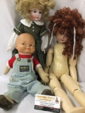 Three vintage porcelain and soft vinyl dolls from Osh Kosh BGosh and others. Largest doll is