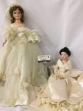 Two large composite and porcelain dolls in wedding dresses. Larger doll measures approximately