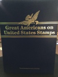 Great Americans on U. S. Stamps book w/ mint stamps next to its 22K gold replica