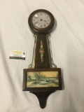 One antique Gilbert windup Banjo wall clock with pastoral image, untested. Approx 21.5x7.5x3 inches.