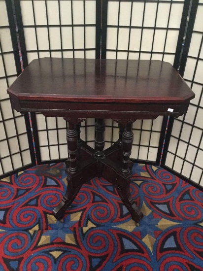 Antique Eastlake style parlor table with wooden caster and carved legs