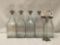 Collection of 5 printed glass liquor bottle decanters with stoppers. Labeled for Rye, Bourbon,