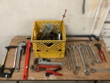 Yellow milk crate full of hand tools, wrenches, pliers, saws and more handy items.