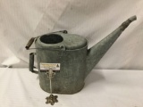 Vintage metal watering can with wood handle.