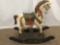 Antique wooden rocking horse with colorful painted adornments and dark base