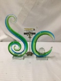 Pair of green and blue glass sculpture art in the shape of an S and a C