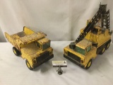 Two vintage Nylint metal Tonka toy trucks. One is a dump truck and the other is a crane excavator