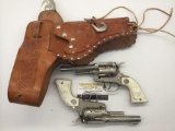 Pair of 50s Hubley Texan Jr die cast pistol cap gun pistols with ornate double holster -