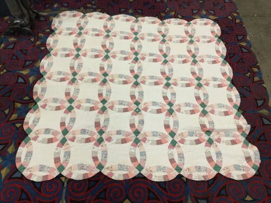 Large vintage hand made quilt feat. an overlapped circular pattern with some light wear