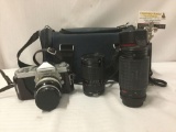 Nikon Nikkormat vintage SLR camera with two extra lenses, an Albinar lens, and an unmarked lens w/