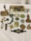 Miscellaneous metal and composite ornamental items, incl. badges, pins, beads, and more. Approx.
