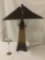 Modern Quoizel wooden lamp w/red composite shade, tested and working, approx. 17x17x25 inches.