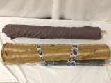 Three rolls of brown, purple, and blue fabric, approx. 56x10x10 inches.