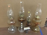 Collection of four Eagle brand Amber tone vintage glass oil lamps.