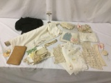 Lot of misc. fabrics, doilies, and clothing items, incl. a black dress, approx. 20x14x13 inches.