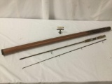 Vintage 7 foot cork handled fishing rod with storage tube, approx. 55x3x3 inches.