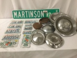 11 license plates and 11 vintage hub caps, incl. Ford, Chevy, and more, approx. 22x16x16 inches.