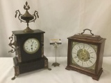 Two mantle clocks, incl. one German Cuckoo Clock Mfg. Co. & one black unmarked clock, approx.