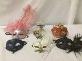 Six colorful party masks, half decorated with feathers, approx. 7x16x3 inches.