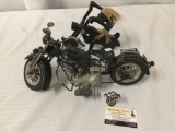 Pair of motorcycle themed wood and metal sculptures. The largest measures approx 16x10x4 inches.
