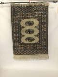 Hanging Eastern rug with geometric pattern with hanging bar
