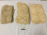 Three doiley/lace type ornamental table clothes, largest approx. 80x55 inches.