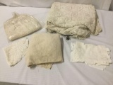 Lot of white lacey sheets, doilies, place mats, and a thick wool blanket.