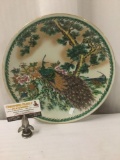 Vintage Asian ceramic plate depicting colorful peacock scene, approx. 12x12x2 inches....