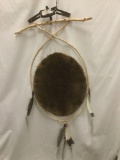 Hanging Native American style art piece with a stretched beaver hide, game trap and feathers etc