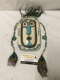 Stoneware mask w/green stone and peacock accents titled 