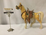 Plaster statue of horse with leather saddle. Has some chips and a repair.