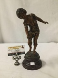 Metal statue of boy playing marbles signed by artist. Made in France.