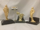 Three antique gold tone metal statues of glamorous women w/dark metal bases, approx. 6x6x10 inches.