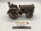 Rare 1930s McCormick Deering cast iron tractor toy with attached driver figure, approx 7x4x4 inches.