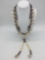 Two necklaces, one featuring bone beads, shells, blue glass and brass beads, and the other features