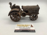 Rare 1930s McCormick Deering cast iron tractor toy with attached driver figure, approx 7x4x4 inches.