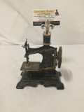 Antique metal miniature sewing machine. Measures approx 6x7x3.5 inches.