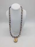 Long necklace features many Russian blue trade beads, carved bone skull beads, and fossilized walrus