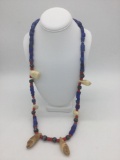 Long necklace featuring 6 fossilized seal teeth and 101 glass African trade beads. Necklace measures