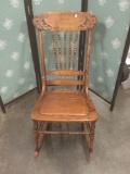 Antique early 20th century rocking chair with hand carved detailing.